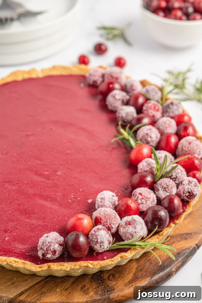 closeup of fresh cranberries on top of a cranberry curd tart