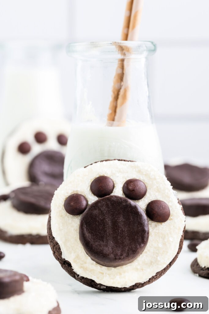 Arctic Paw Prints 4 A freshly decorated Polar Bear Paw Cookie sitting beside a refreshing glass of milk, inviting a delightful taste