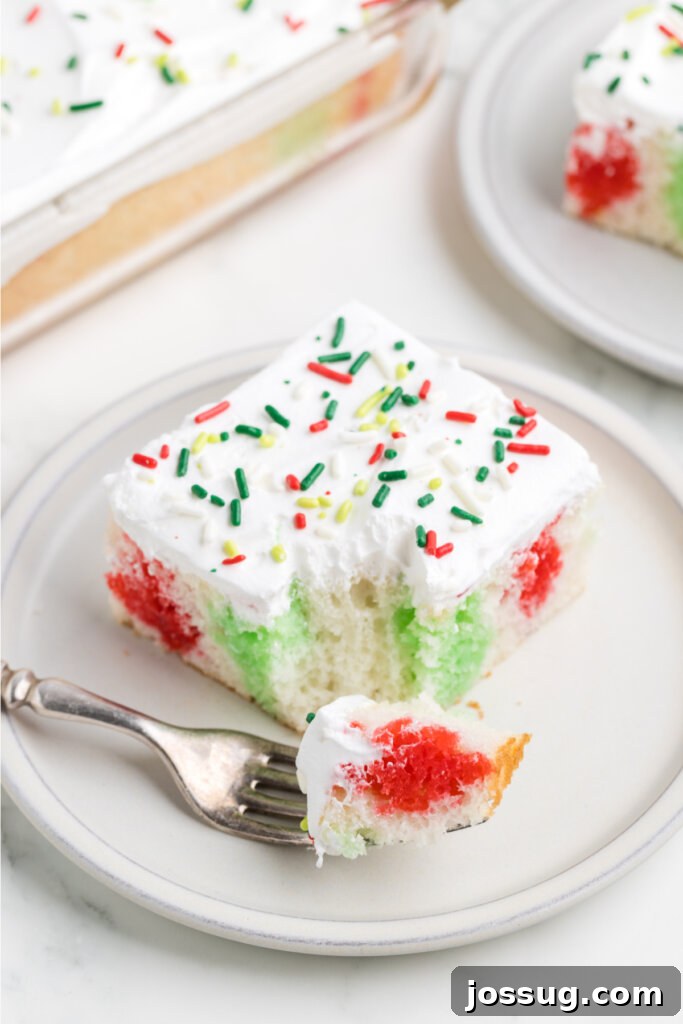 Festive Surprise Poke Cake 3 slice of christmas poke cake with bite on spoon laying on plate