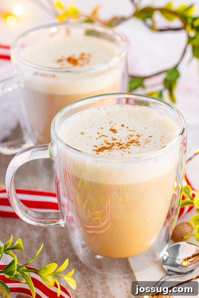 Yuletide Velvet Latte 2 A beautifully crafted eggnog latte in a clear mug, garnished with a sprinkle of nutmeg, evoking a warm holiday feeling.