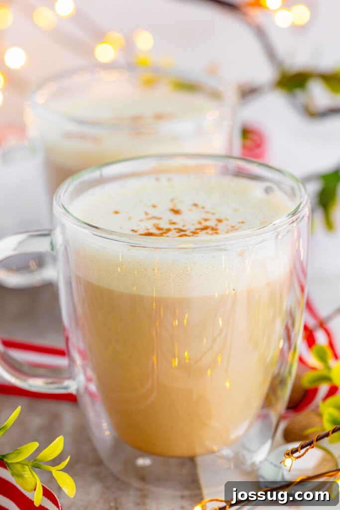 Yuletide Velvet Latte 4 A close-up shot of an eggnog latte in a clear mug, highlighting the smooth texture and warm color of the drink.