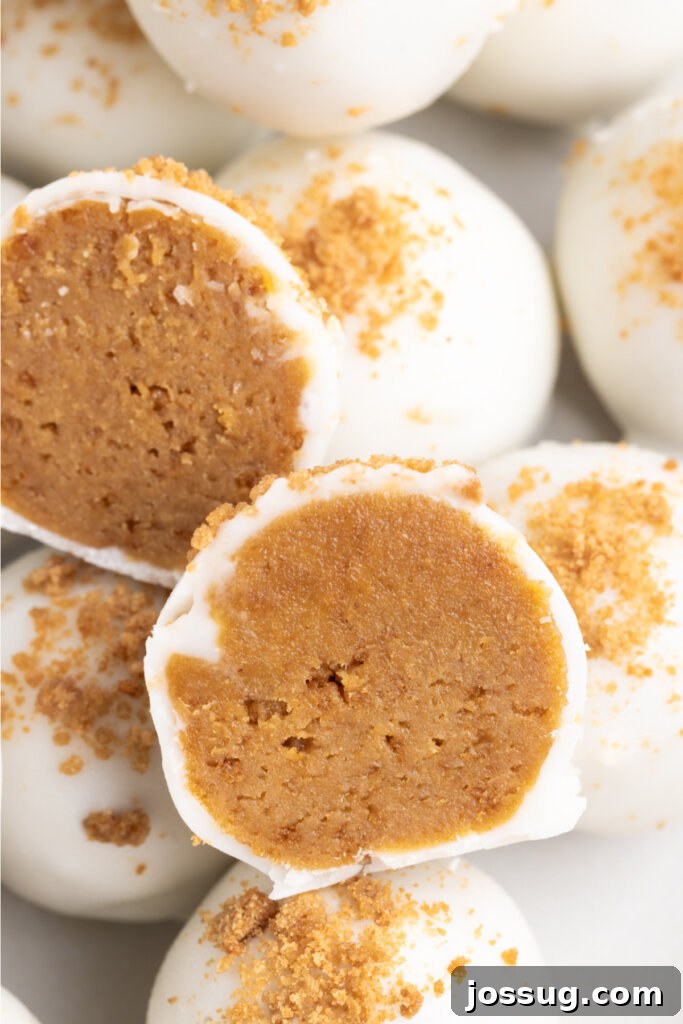 A close-up view of a gingerbread truffle sliced open, highlighting its rich, spiced cookie and cream cheese filling.