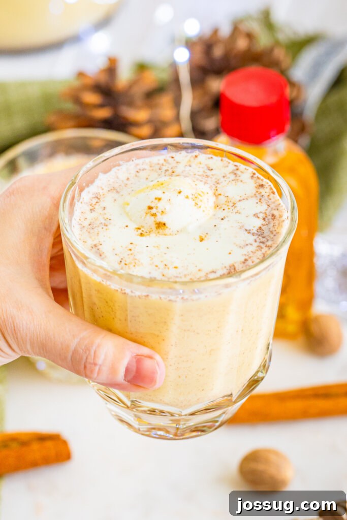 Holiday Eggnog Cheer 5 hand holding a glass of eggnog punch