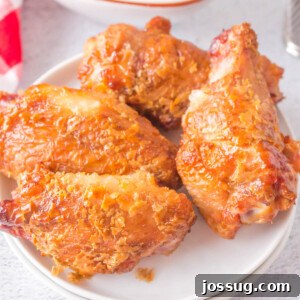 four grilled crispy chicken wings on plate