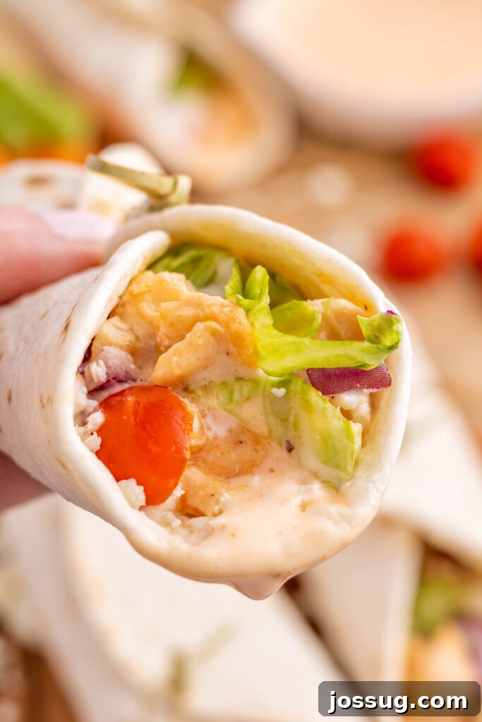 Spicy Buffalo Chicken Roll-Ups 5 hand holding a buffalo chicken wrap