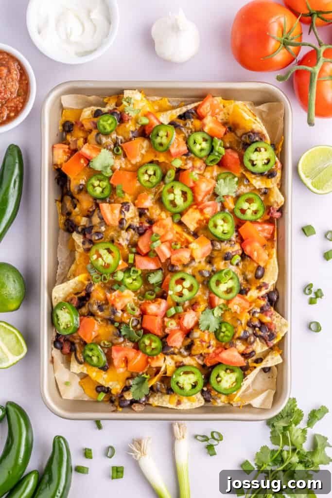 Volcano Black Bean Nachos 3 A close-up view of a sheet pan generously filled with spicy loaded black bean nachos, ready to be served.