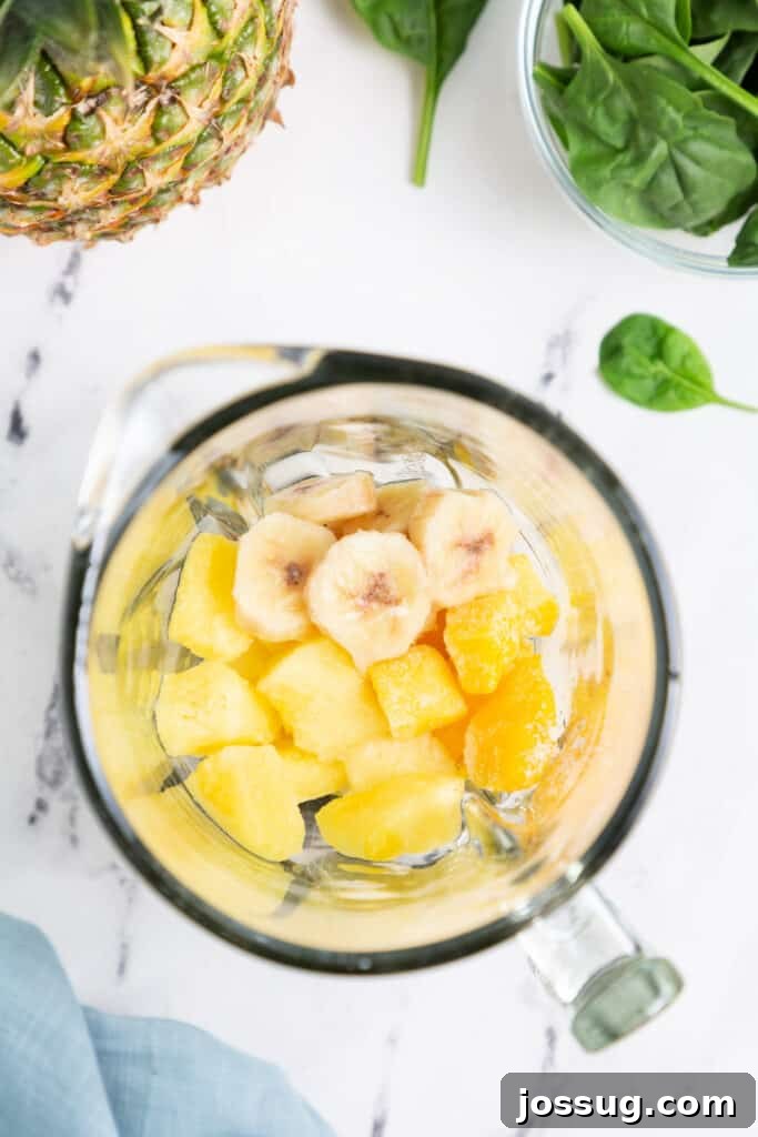 Add the frozen pineapple, mango, and banana to the blender.