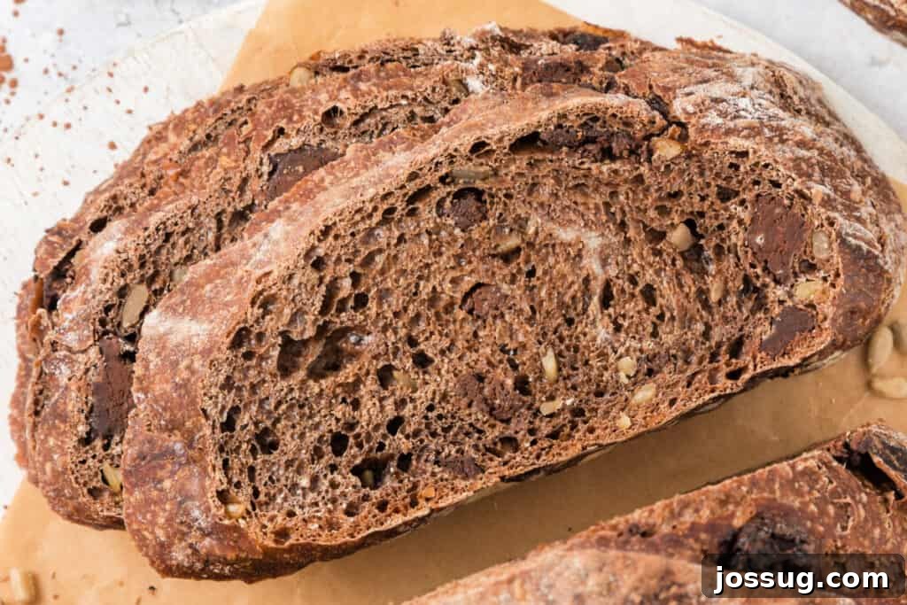 A close-up of multiple slices of chocolate no-knead bread stacked, revealing the dense chocolate chunks within