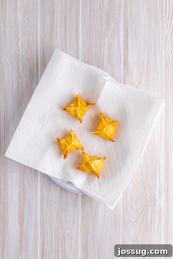 Crispy Crab Clouds 13 Heat a deep fryer or dutch oven with 4 inches of oil to 350°F. Very carefully place a couple of the crab rangoon into the hot oil at a time and fry until golden brown. Place the fried rangoons on a paper-towel-lined plate to soak up any excess oil ...