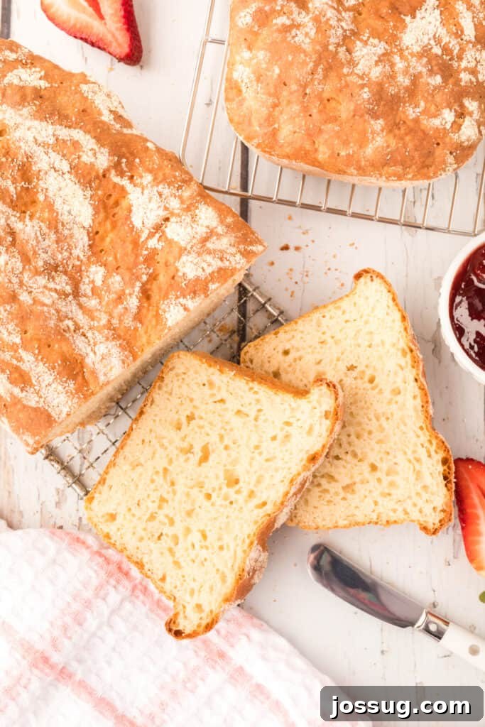 Two golden loaves and several slices of homemade English Muffin Bread, ready for toasting and enjoying.