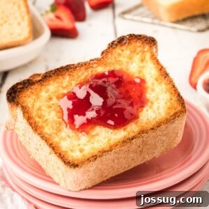 closeup of toasted english muffin bread with jam on pink plates