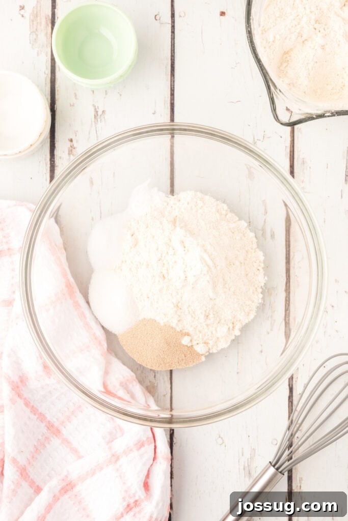 In a large bowl, whisk together 2 cups flour, yeast, sugar, salt, and baking soda.