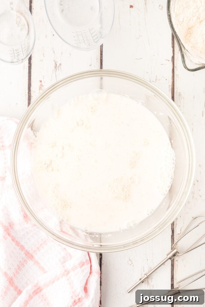 Add warm milk and water; beat with a mixer on low speed for 30 seconds, scraping down the bowl occasionally. Increase the mixer speed to high and beat for 3 minutes. 