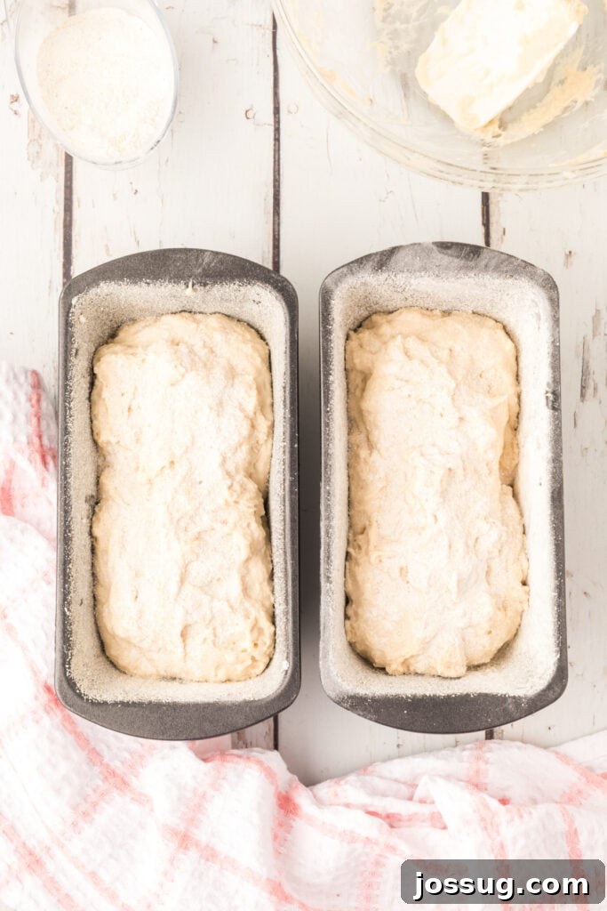 Divide and spoon the stiff batter evenly into the prepared loaf pans, then sprinkle more cornmeal on top.