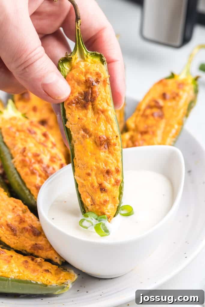 buffalo chicken jalapeno popper being dipped into sauce