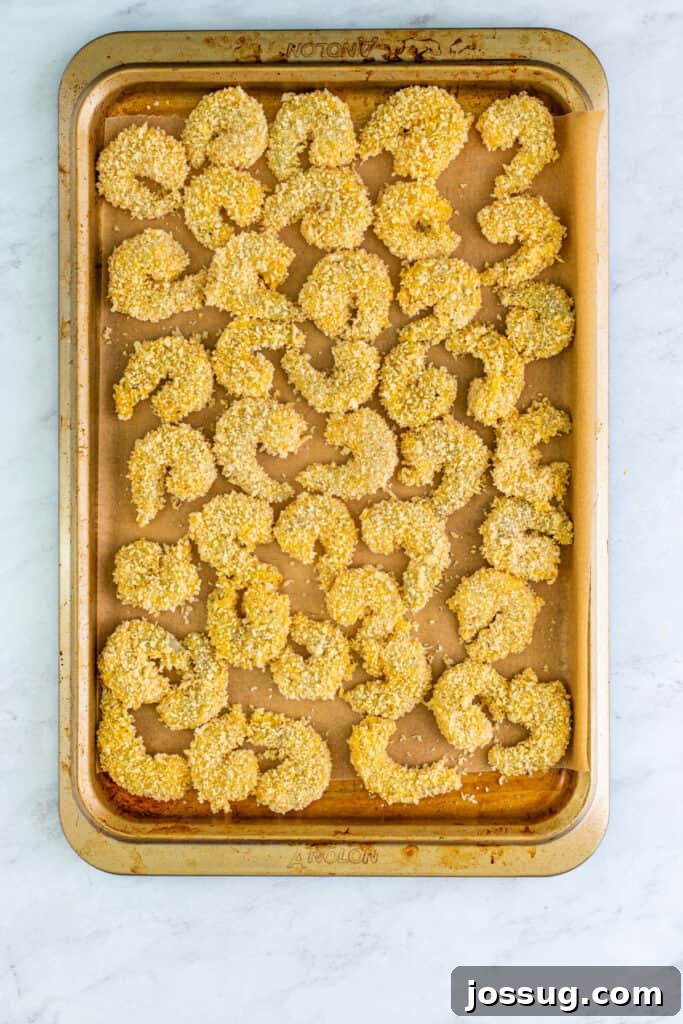 Place breaded shrimp on a parchment-lined tray.