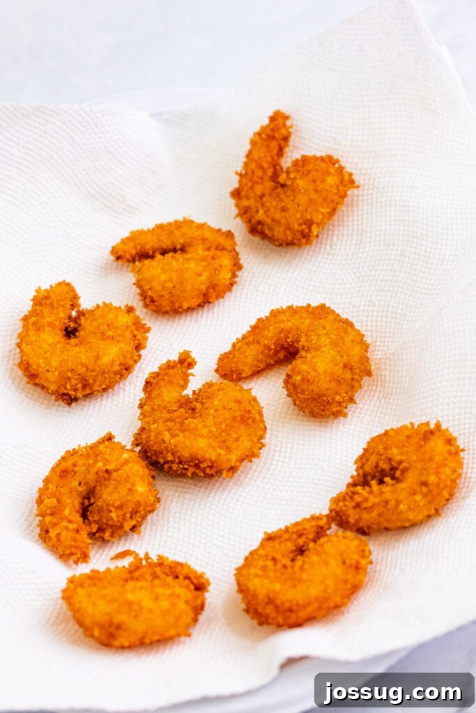 Drain fried shrimp on paper towels ...