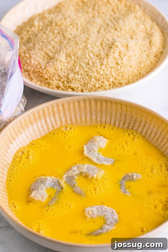 In a shallow bowl, whisk eggs with water. In another shallow bowl, place breadcrumbs. Dip shrimp in egg mixture ...