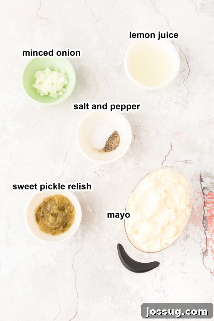 Creamy Dill & Caper Dressing 3 Various fresh ingredients laid out on a wooden board, ready to be mixed for tartar sauce.