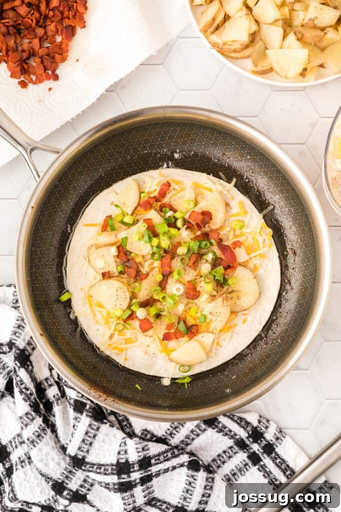 Gourmet Spud Quesadilla 4 layers of a loaded baked potato quesadilla in a skillet before the top tortilla goes on