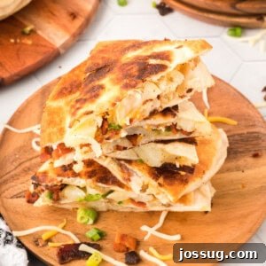 Gourmet Spud Quesadilla 7 closeup of loaded baked potato quesadilla pieces stacked on wooden cutting board