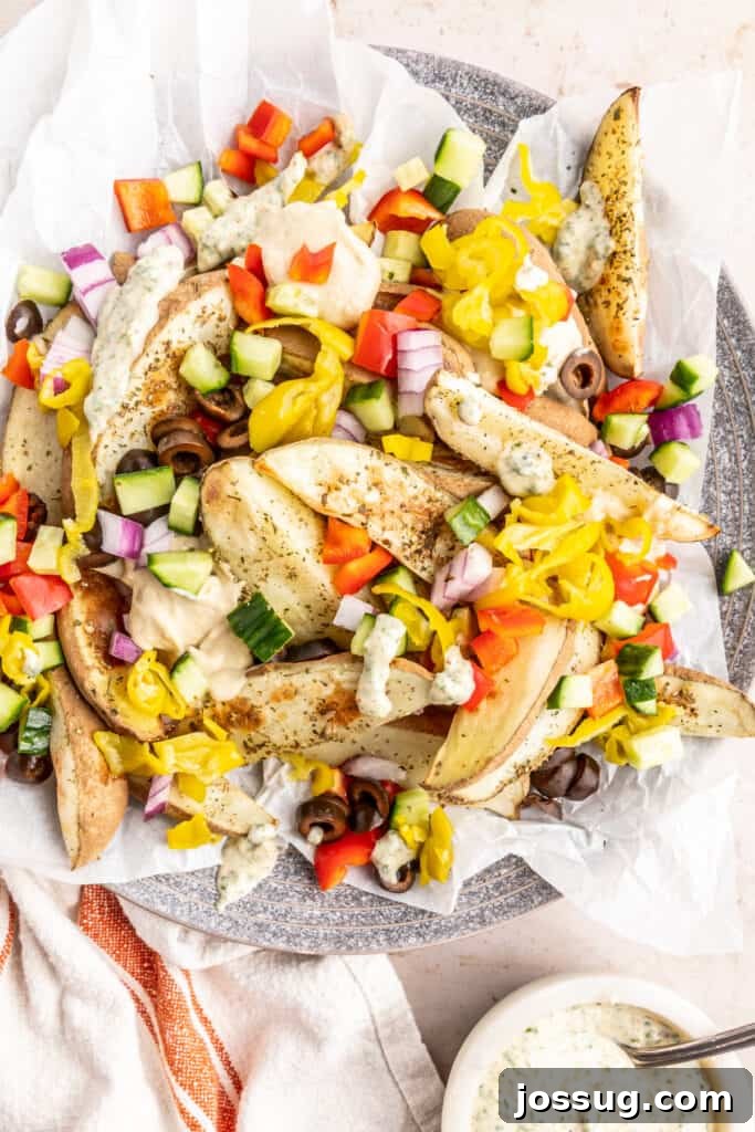 Mediterranean Potato Wedge Feast 8 Close-up of freshly baked and loaded potato wedges, generously topped with banana peppers, diced cucumbers, vibrant red onion, black olives, and a tantalizing drizzle of creamy herb sauce, highlighting the colorful medley.