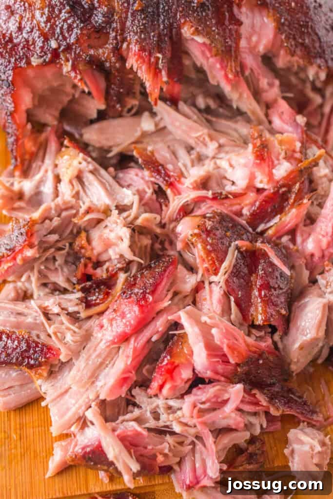 Close-up of freshly shredded grilled pulled pork showing tender meat and crispy bark, ready to serve.