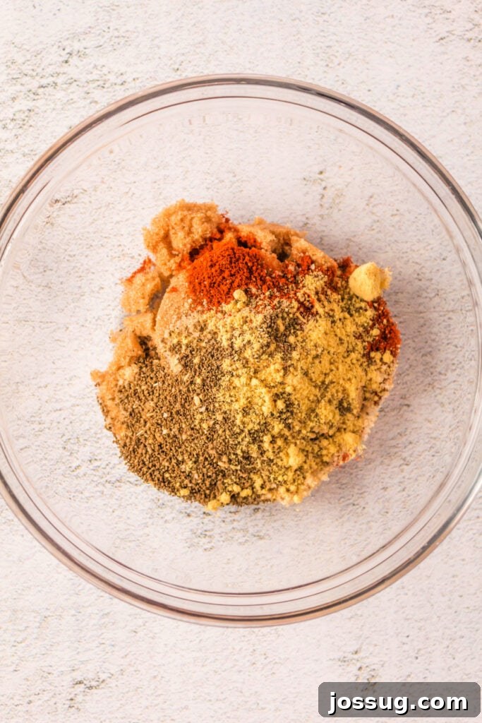 Close-up of all dry rub ingredients mixed together in a clear glass bowl, showcasing the texture and color.
