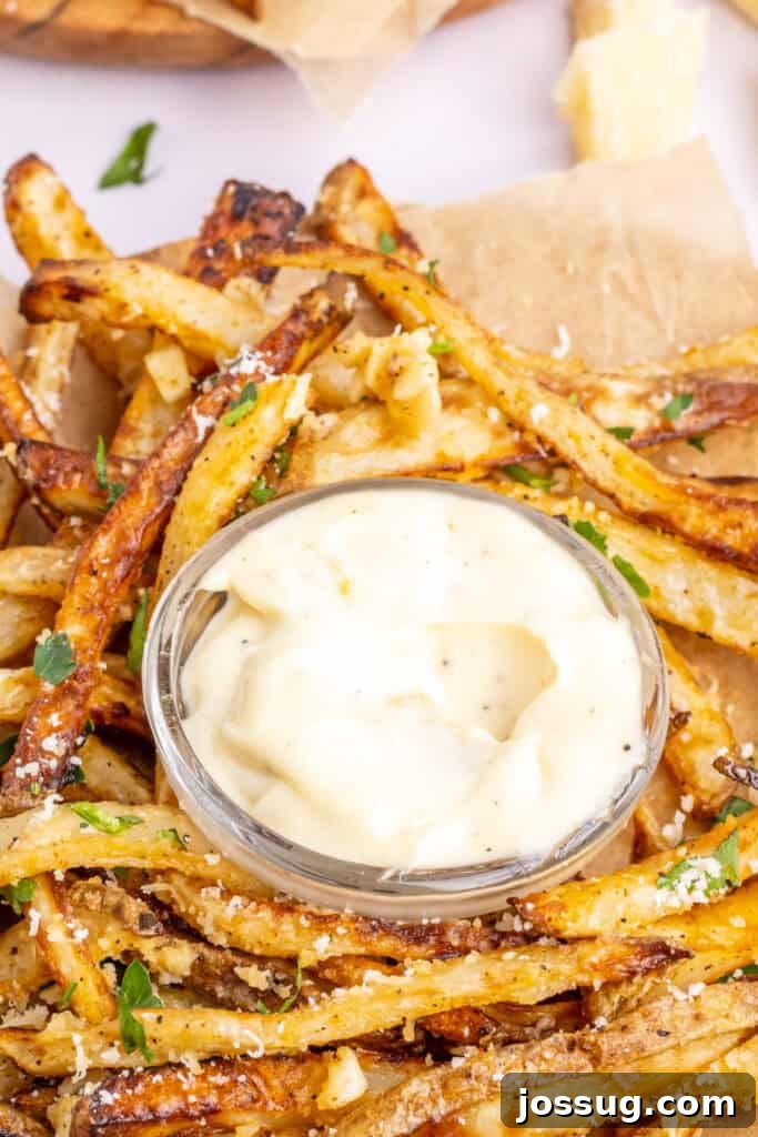 garlic aioli in small glass bowl with homemade fries around the bowl