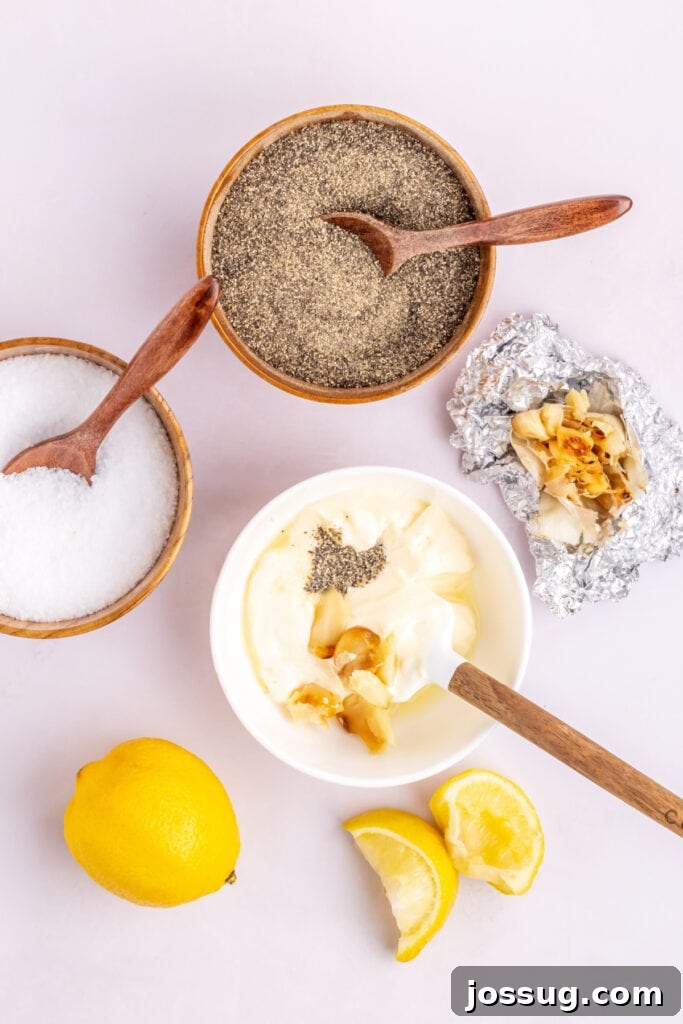 Once the garlic is roasted, carefully unwrap it and squeeze the garlic cloves out of their shell into a small bowl. To the bowl, add the mayonnaise, freshly squeezed lemon juice, salt, and pepper.