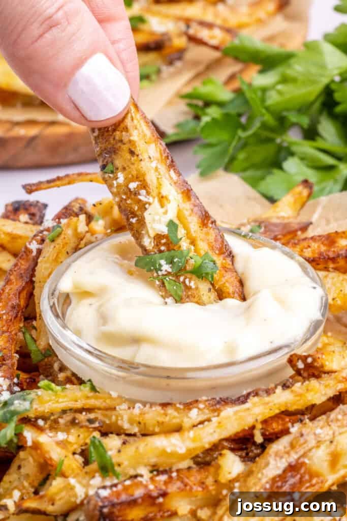 fries being dipped into garlic aioli