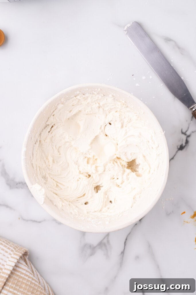 Creamy, fluffy cream cheese frosting prepared in a mixing bowl, showcasing its smooth texture