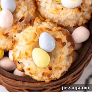 Close-up of golden-brown coconut Easter nests filled with colorful mini egg candies in a white bowl.