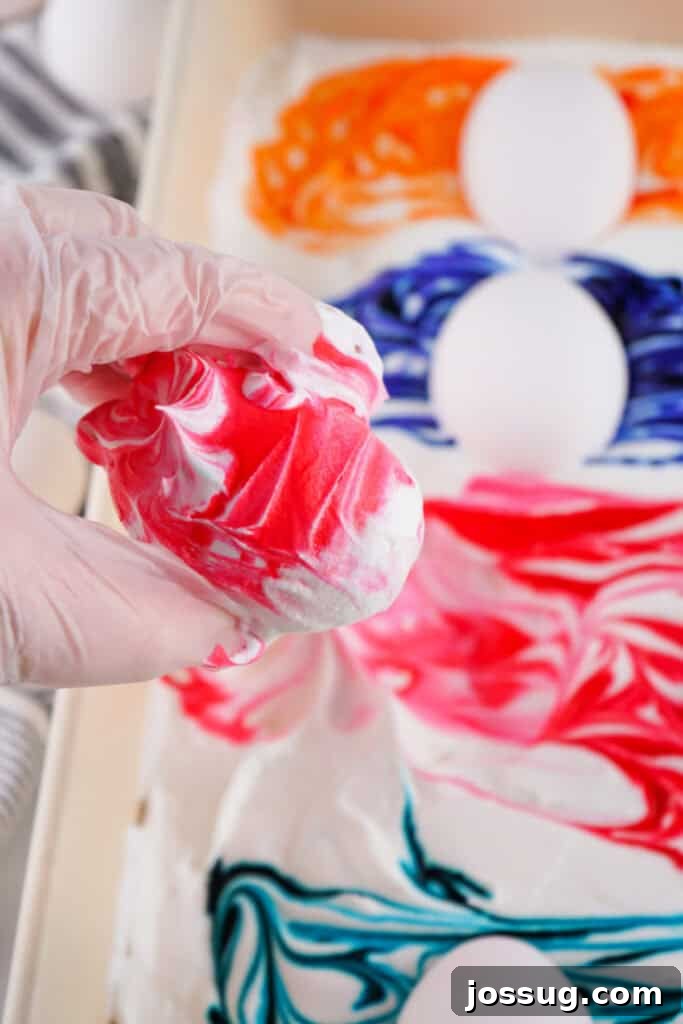 Cool Whip Marbled Easter Eggs 7 A hand holding a beautifully finished Cool Whip dyed Easter egg, showcasing its vibrant marbled design