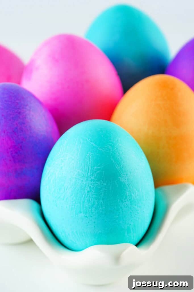 Assorted vibrant food coloring dyed Easter eggs nestled in a carton