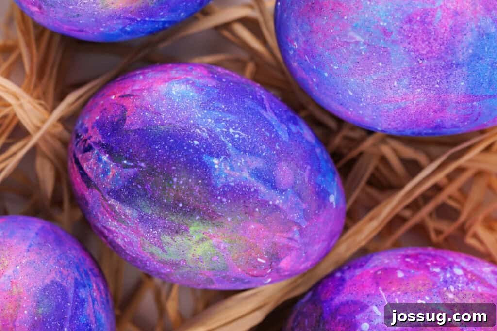 Cosmic Curiosities Uncovered 9 A close-up view of a single galaxy easter egg, highlighting its intricate dye patterns and tiny white star splatters.