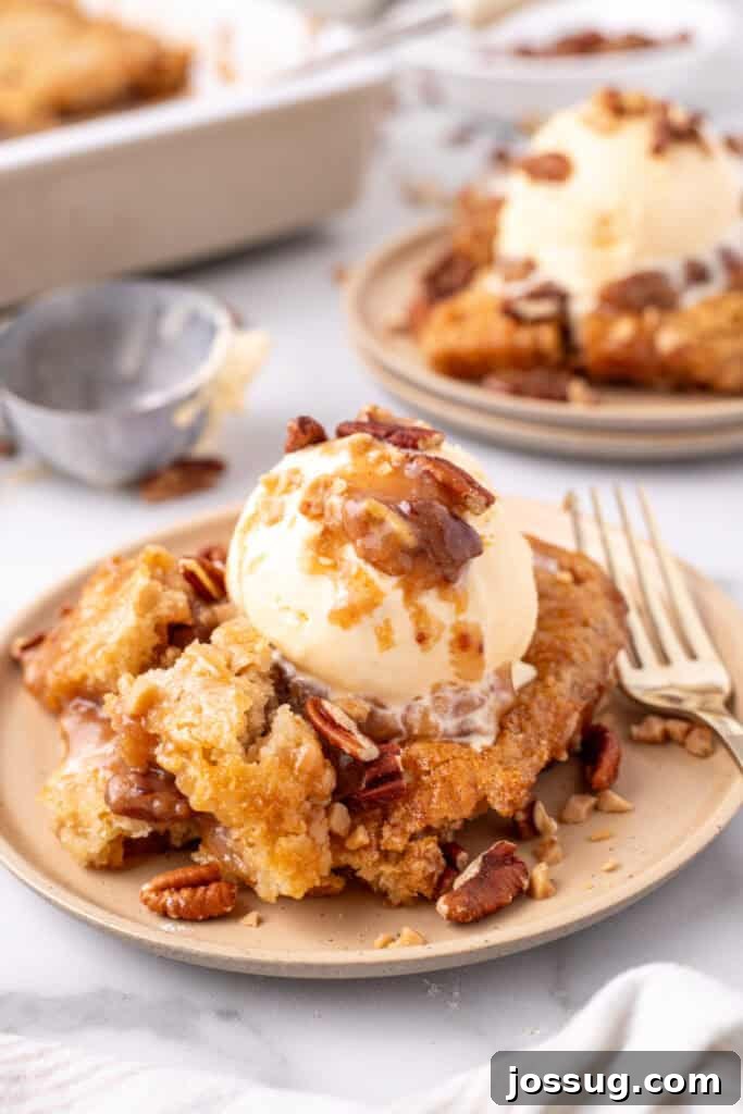 Decadent Pecan Cobbler 2 Warm pecan pie cobbler on a plate, topped with vanilla ice cream
