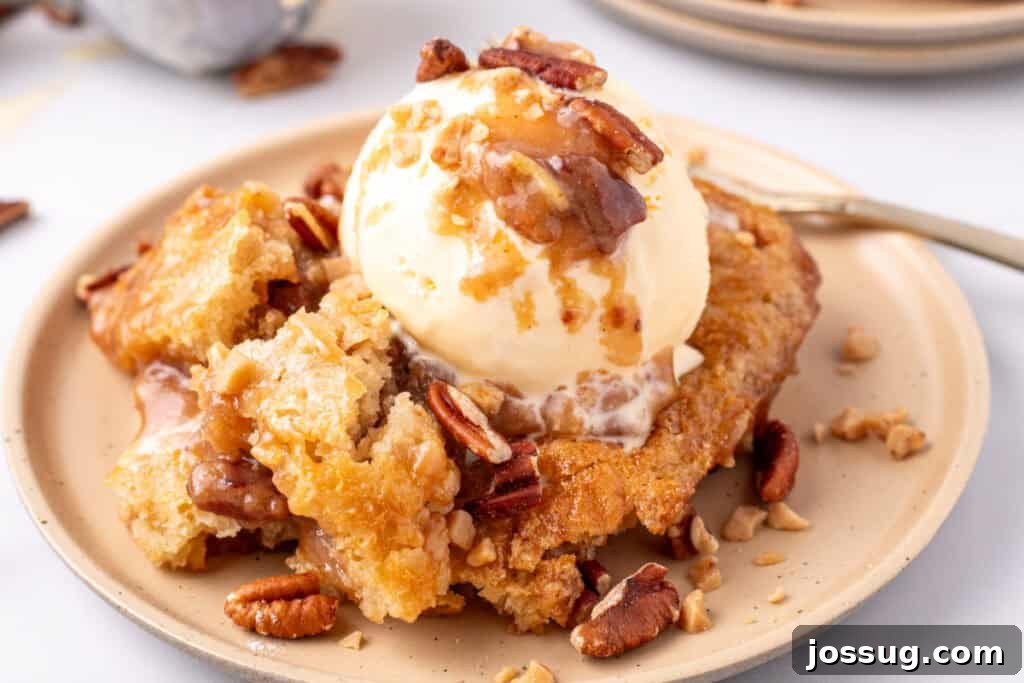 Decadent Pecan Cobbler 9 Scoop of pecan pie cobbler on a white plate with a fork