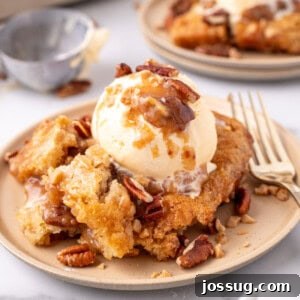 Decadent Pecan Cobbler 10 Closeup of a scoop of pecan pie cobbler on plate with a fork