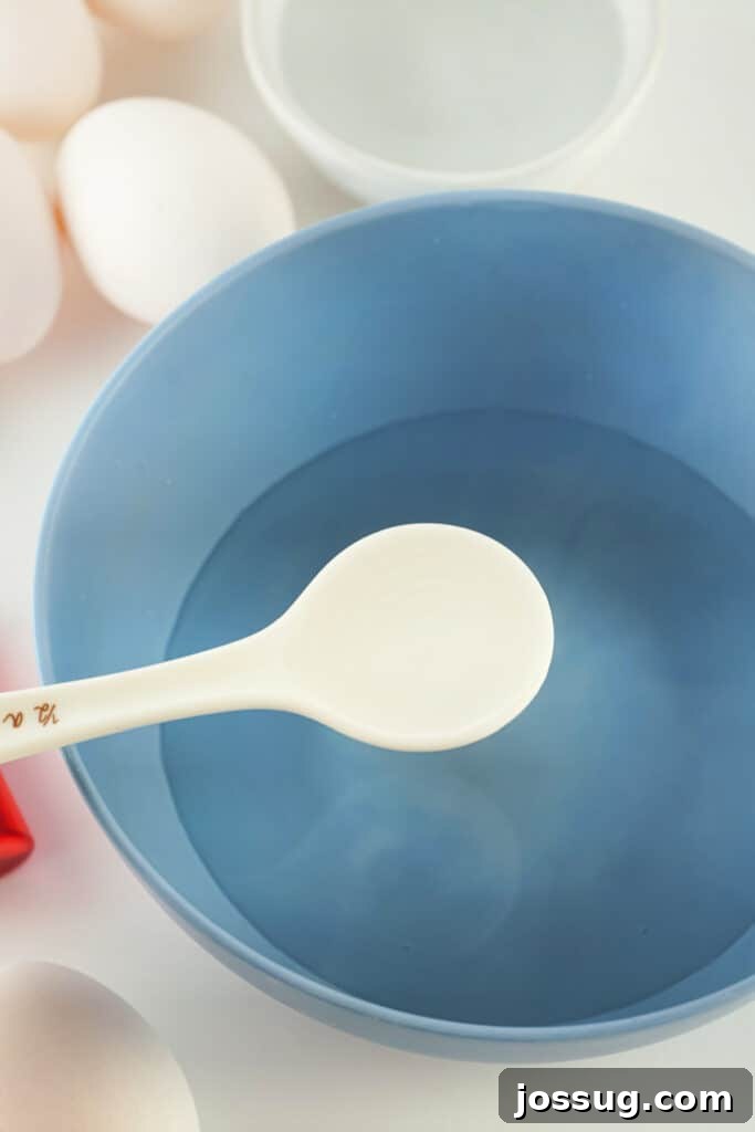 Adding vinegar to a bowl of hot water for the dye mixture
