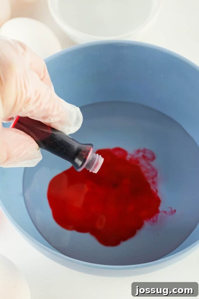 Adding drops of food dye to the vinegar and water mixture