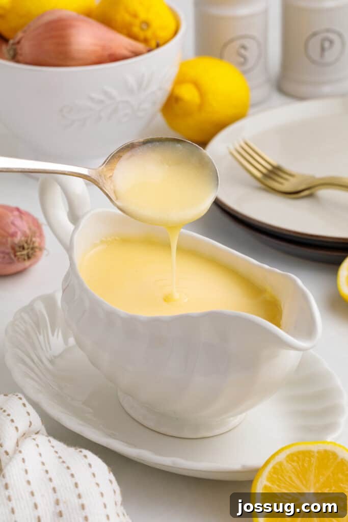 Zesty Lemon Butter Drizzle 2 Spoon pouring silky lemon butter sauce into a gravy boat, highlighting its luxurious texture and vibrant color.