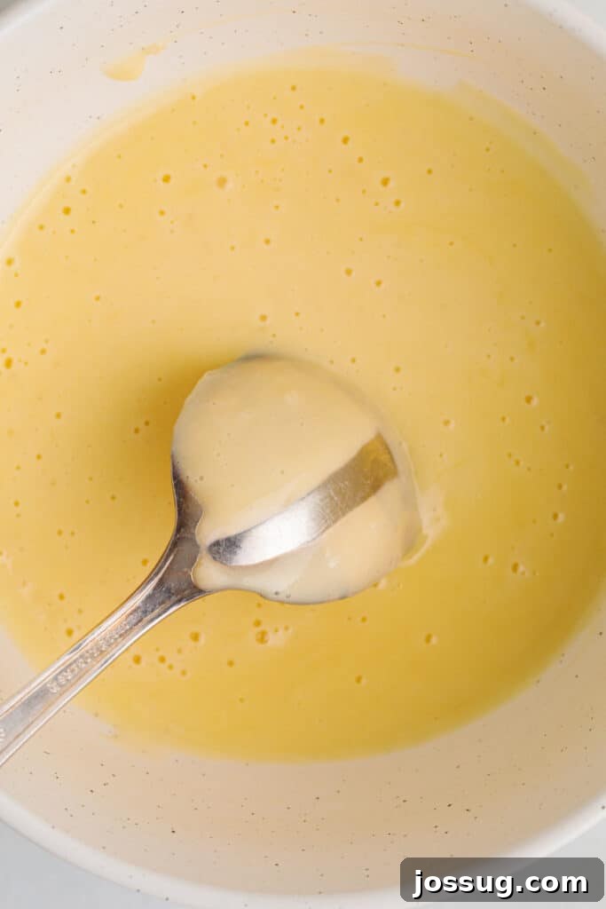 Zesty Lemon Butter Drizzle 7 A close-up of the silky lemon butter sauce coating the back of a spoon, demonstrating its perfect emulsified texture.