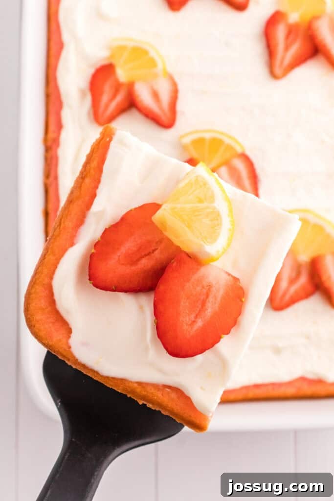 A slice of strawberry cake with lemon cream topping being carefully lifted from the baking dish with a spatula.