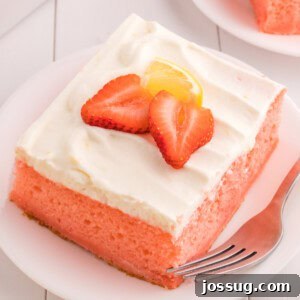 Closeup of a slice of strawberry cake with lemon cream topping on a plate, showing its soft texture and vibrant colors.