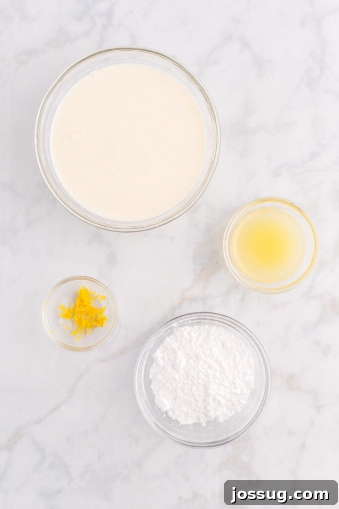Ingredients for the lemon cream topping arranged on a white surface, featuring heavy cream, powdered sugar, fresh lemons for juice and zest, showcasing the fresh components.