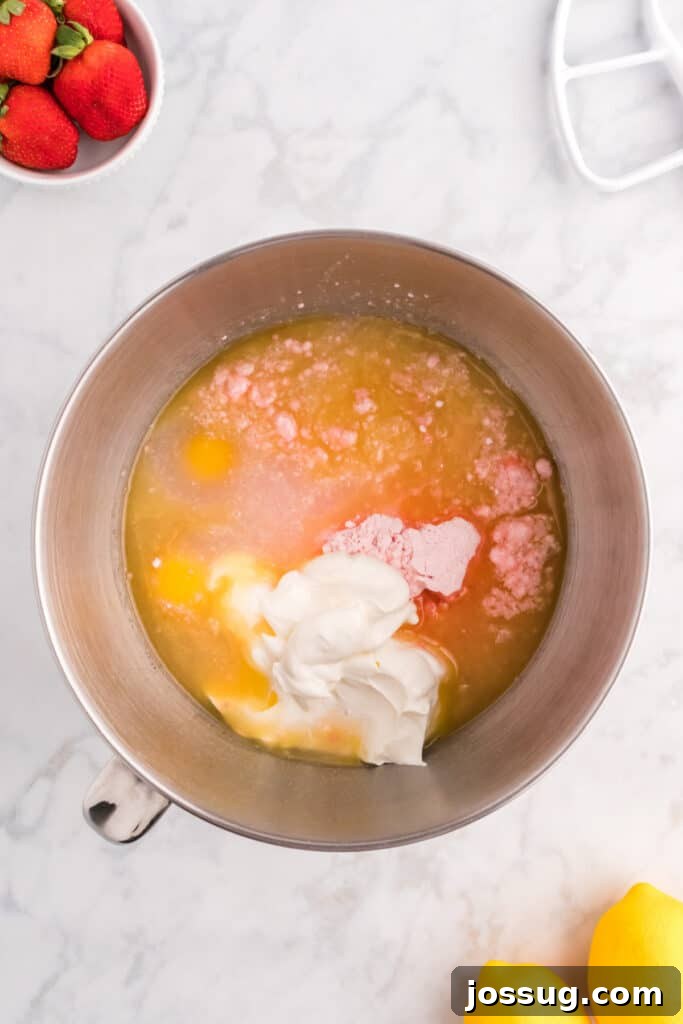 Strawberry cake ingredients in a large mixing bowl, unmixed, showing the various components before whisking into batter.