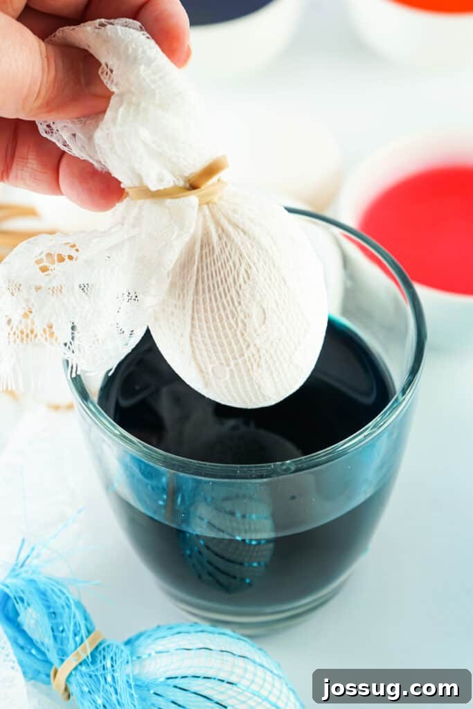 Textile Art Easter Eggs 4 Hard-boiled egg wrapped in lace, secured with a rubber band, ready to be dipped in dye.