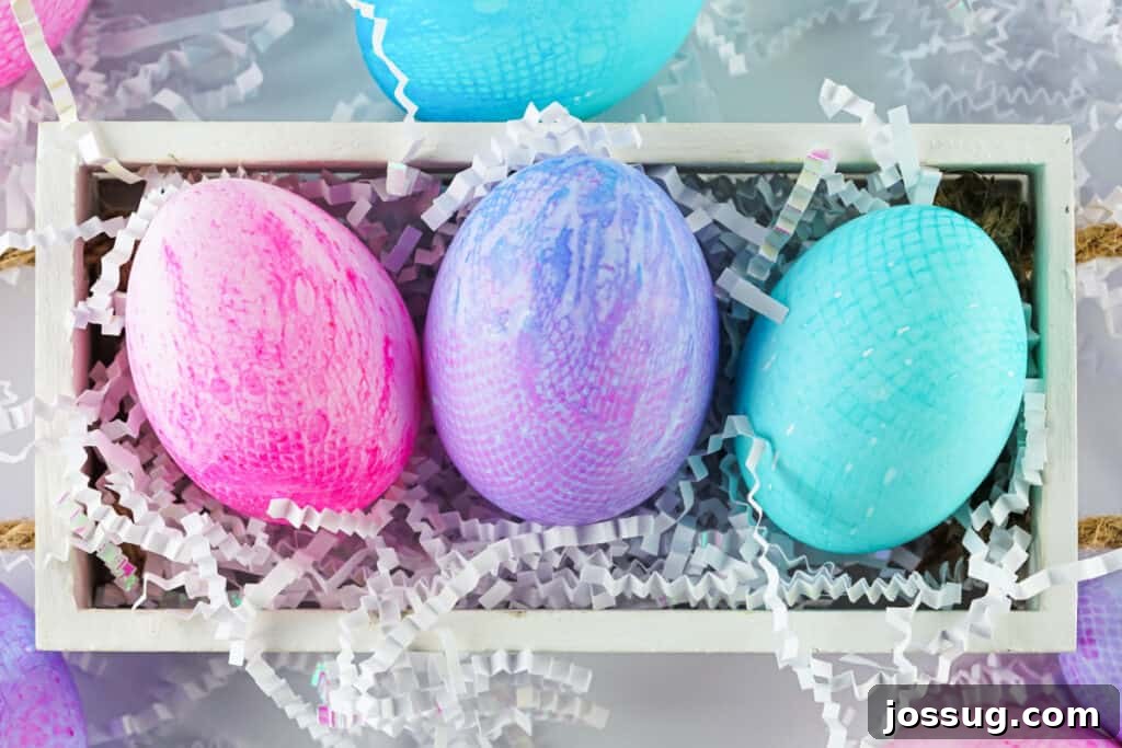 Textile Art Easter Eggs 9 Three different colors of fabric textured eggs in a rustic wooden box, showcasing varying patterns and textures.