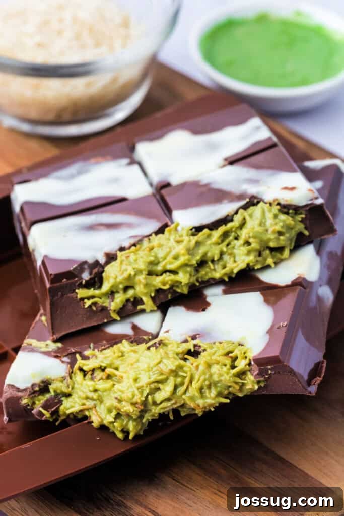 Golden Dubai Delight 2 Close-up side view of two stacked Dubai Chocolate Bar pieces, filled with green pistachio-kataifi mixture and drizzled with white chocolate.